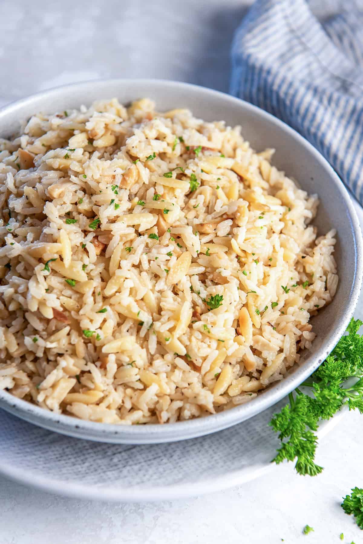 Almond rice pilaf in a white serving bowl.