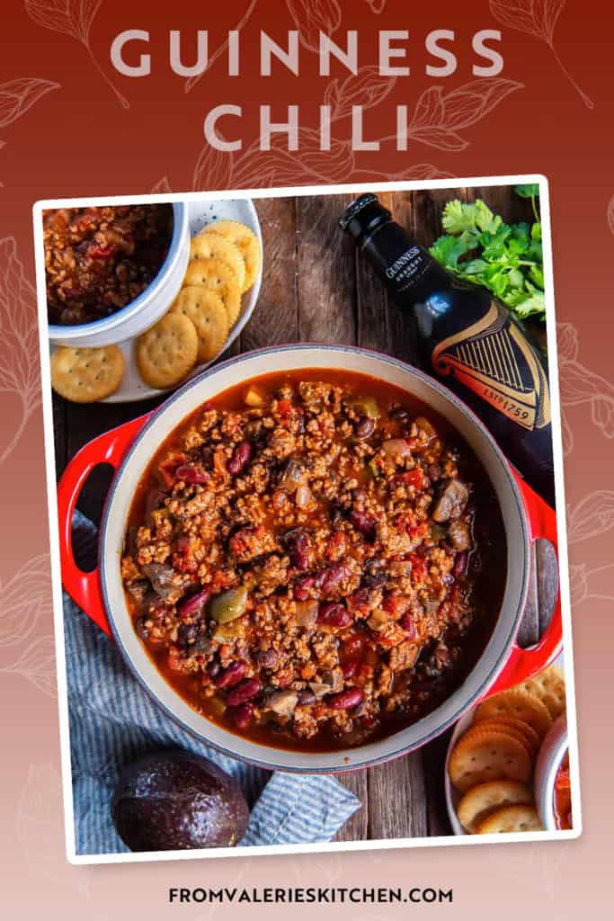 A pot of beef chili with bell peppers and mushrooms next to a bottle of Guinness with text overlay.