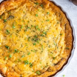 A ham and cheese crustless quiche in a white quiche pan.
