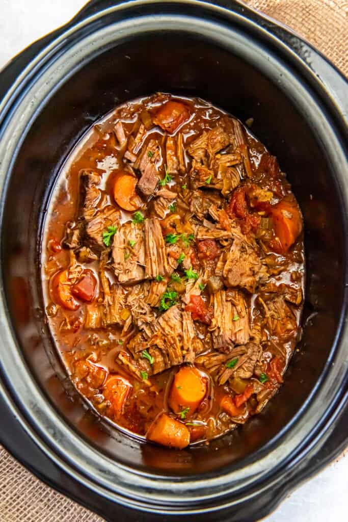 Italian pot roast and carrots in a slow cooker.