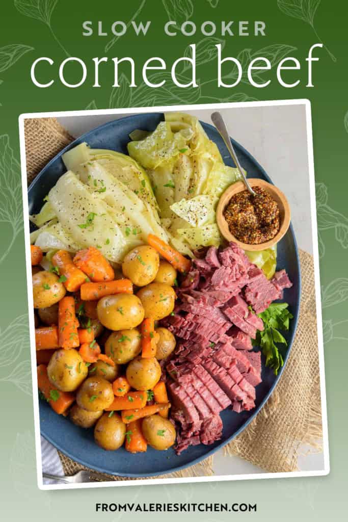 Sliced corned beef on a blue platter with carrots, potatoes, and cabbage with text overlay.