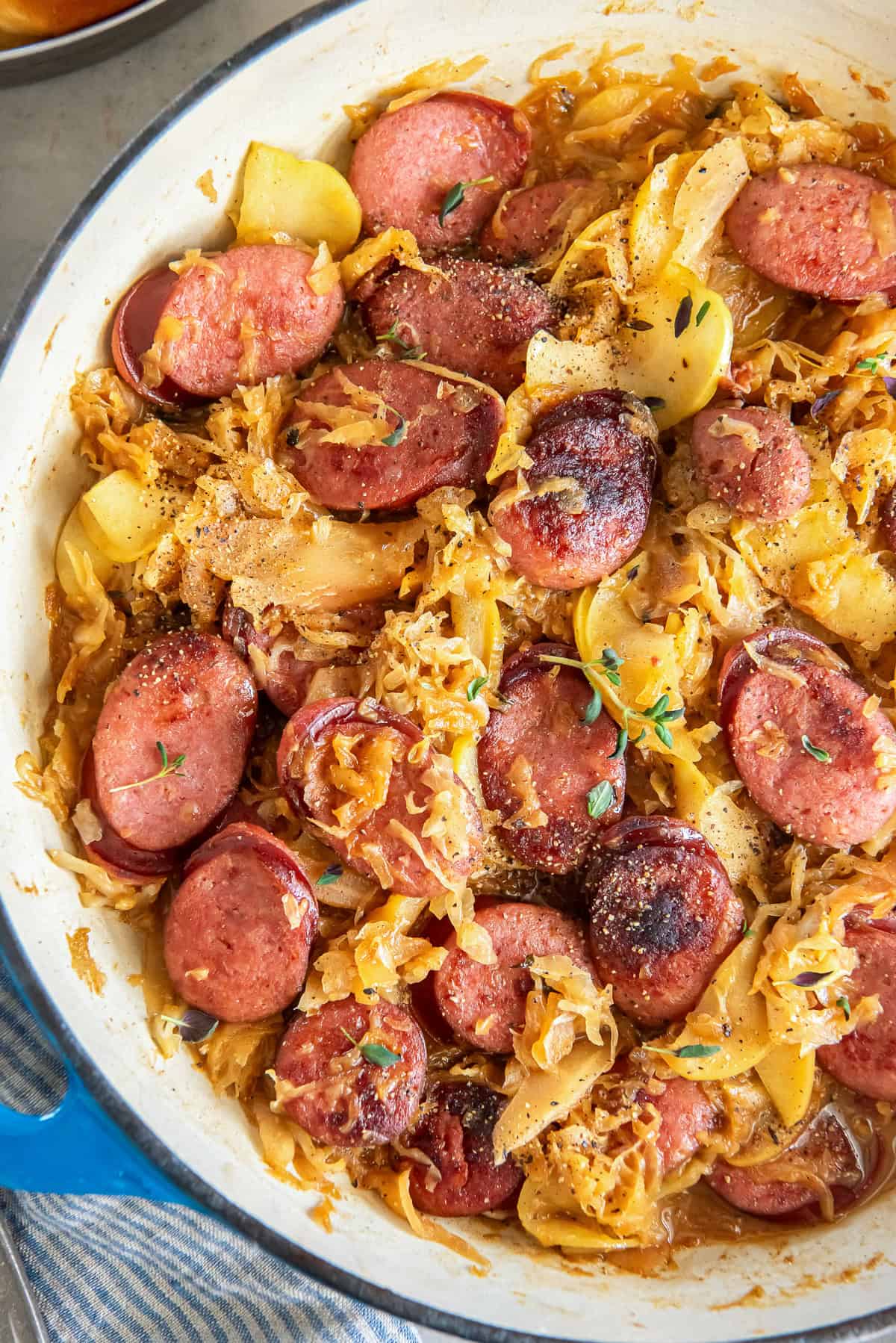 Kielbasa and sauerkraut with apples in a skillet.