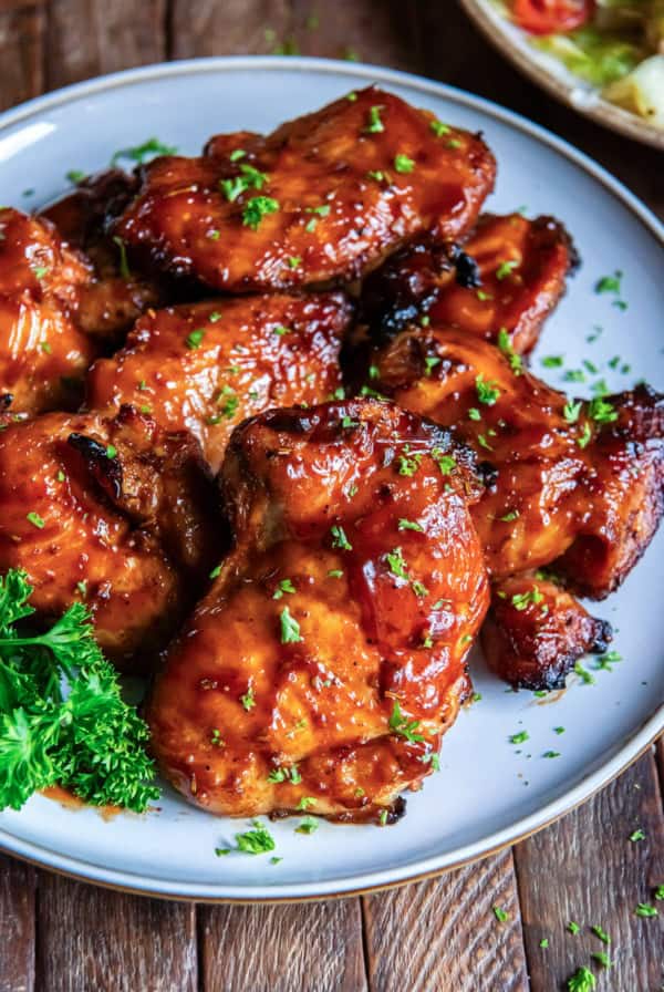 Grilled chicken thighs on a white plate.