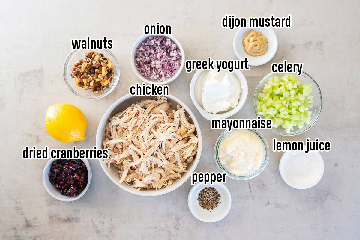 Shredded chicken, greek yogurt, mayonnaise, a lemon and other ingredients in bowls with text overlay.