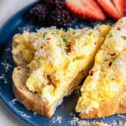 Ricotta scrambled eggs on toast with parmesan and red pepper flakes.