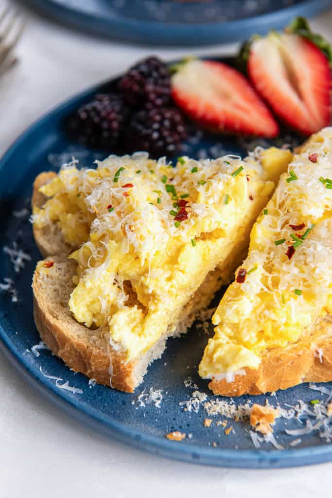 Ricotta scrambled eggs on toast with parmesan and red pepper flakes.