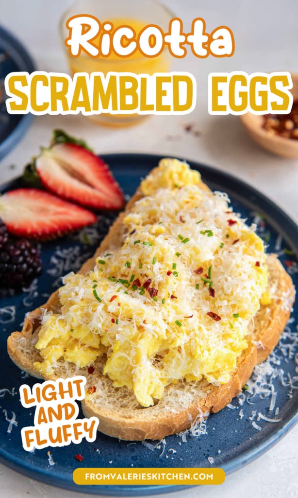 Ritcotta scrambled eggs on toast on a blue plate with strawberries with text overlay.