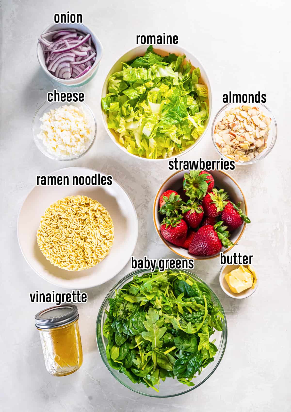Salad greens, strawberries, ramen noodles, and other ingredients in bowls with text overlay.