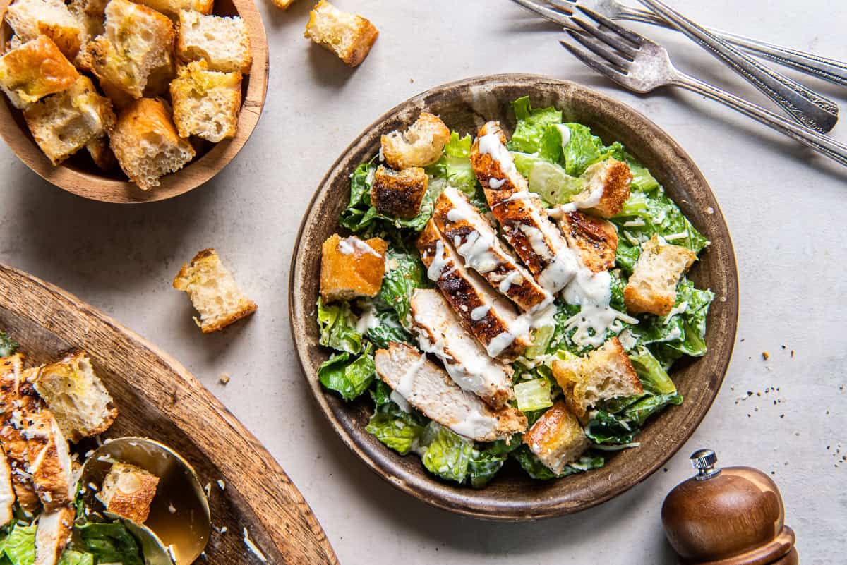 A serving of grilled chicken Caesar salad with focaccia croutons on a salad plate.