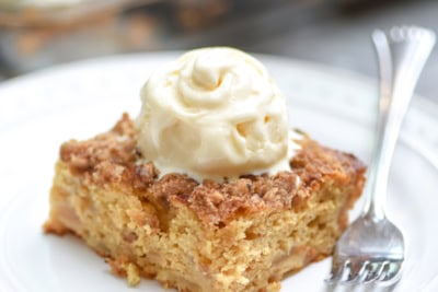 A piece of cake topped with whipped cream on a plate.
