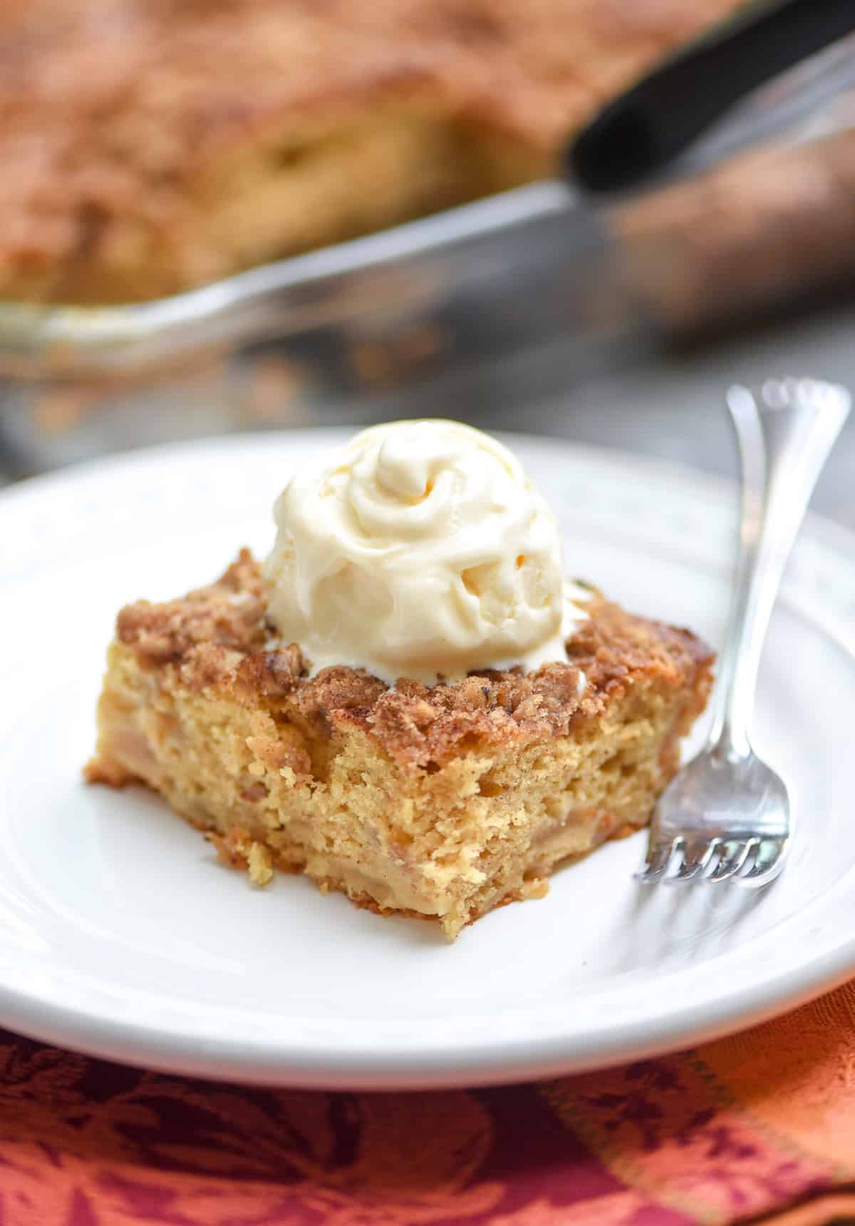 A piece of cake topped with whipped cream on a plate.