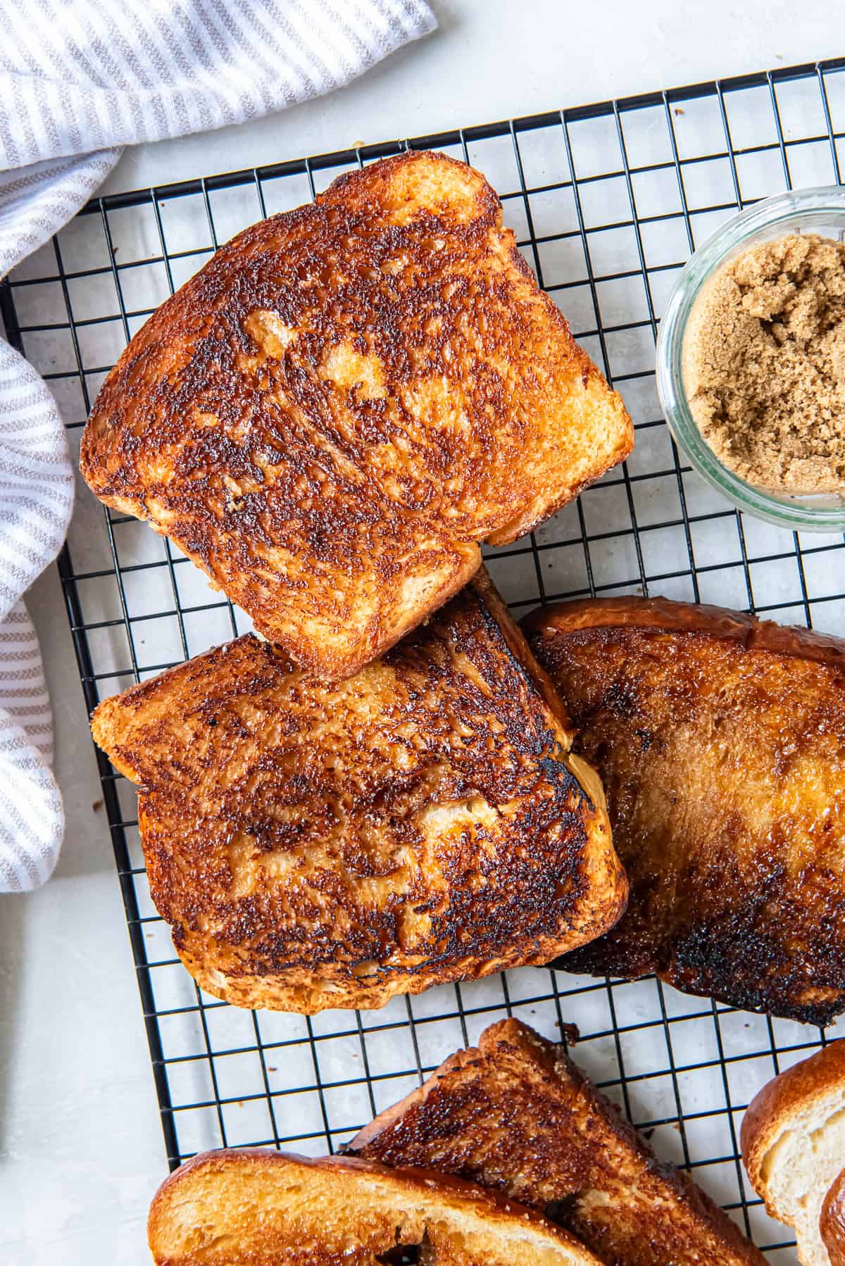 Brown Sugar Toast 6 Several pieces of brown sugar toast on a wire rack with a small bowl of brown sugar.
