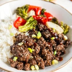 Ground Korean beef in a white bowl with rice and roasted vegetables.