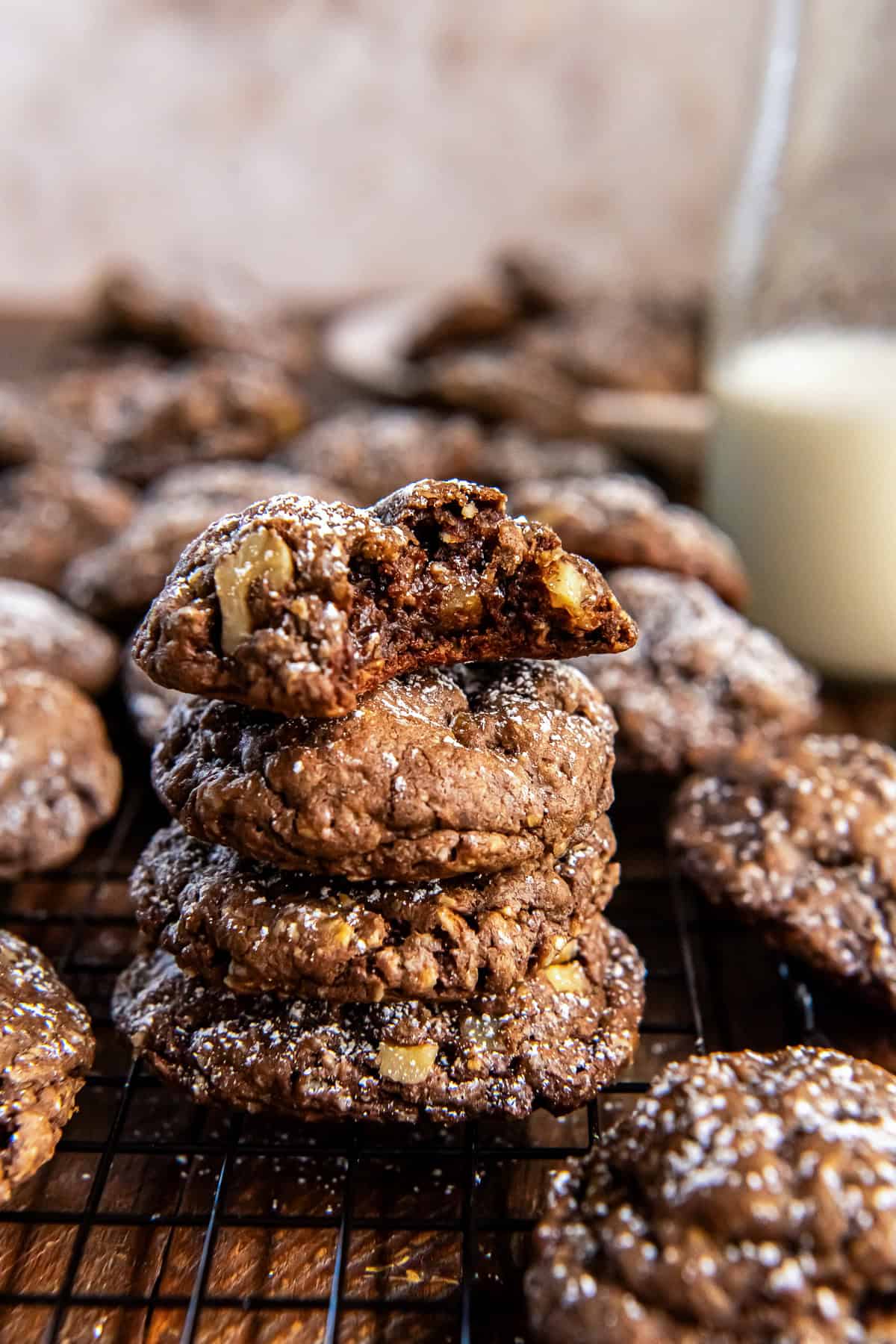 Chocolate Oatmeal Cookies 7 A stack of chocolate oatmeal cookies with a glass of milk in the background.