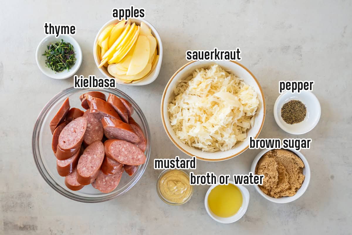 Sliced kielbasa, sauerkraut, apples, and other ingredients in bowls with text overlay.