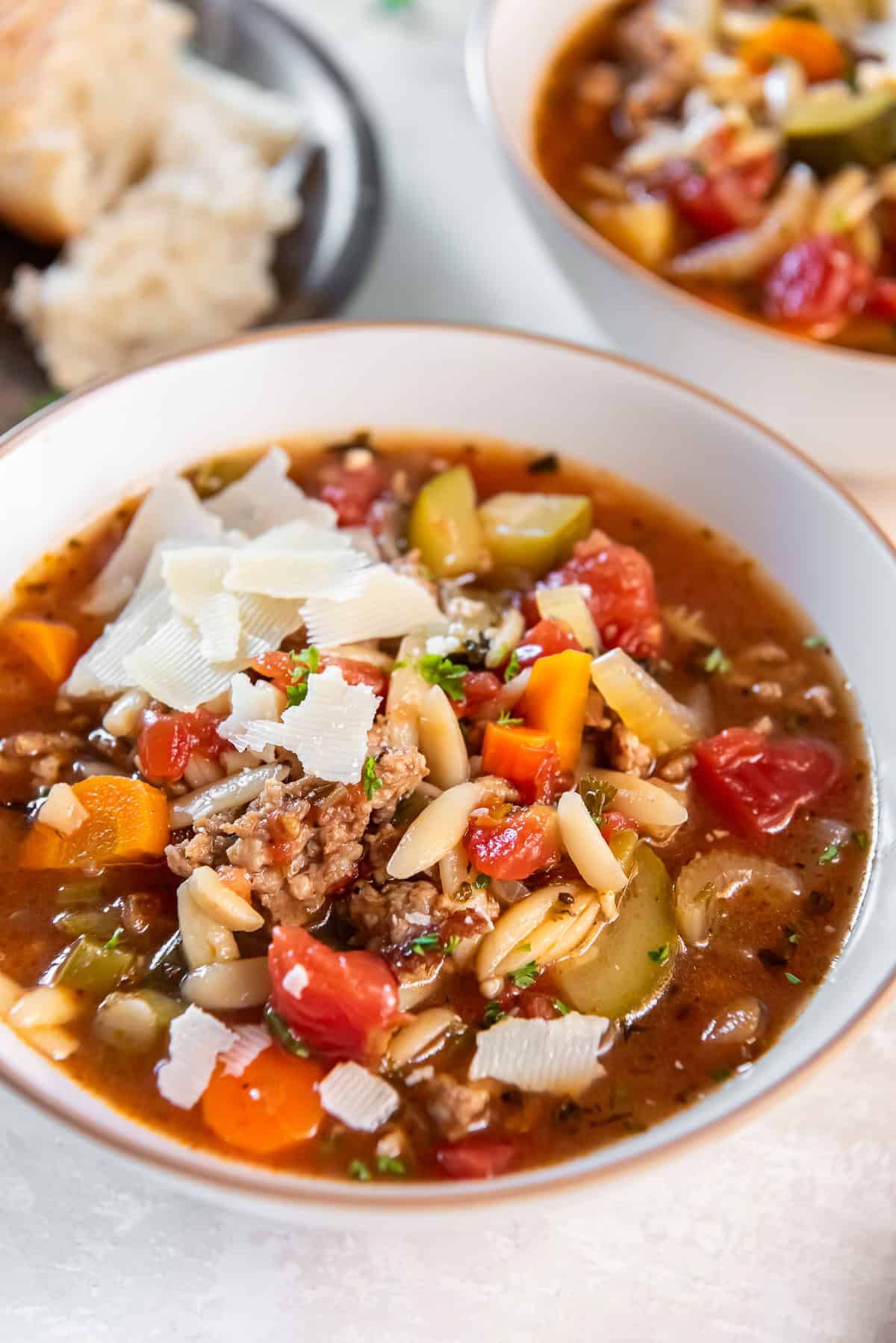 Italian Sausage and Zucchini Soup 7 A bowl of Italian sausage zucchini soup topped with grated Parmesan cheese.