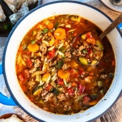 Italian Sausage and Zucchini Soup 8 A ladle resting in a Dutch oven filled with Italian sausage zucchini soup.