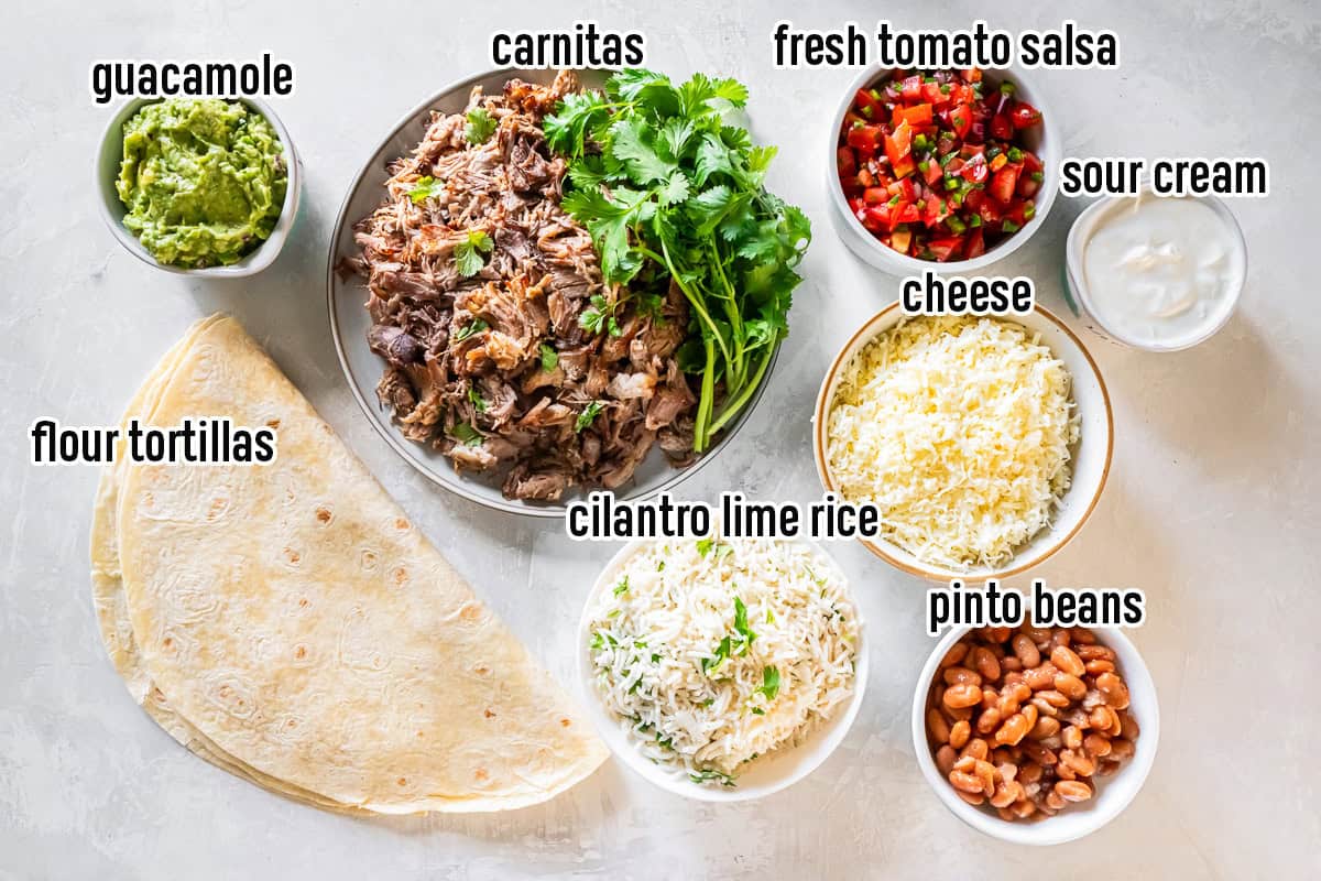 Shredded pork carnitas, flour tortillas, guacamole and other burrito ingredients in bowls with text overlay.