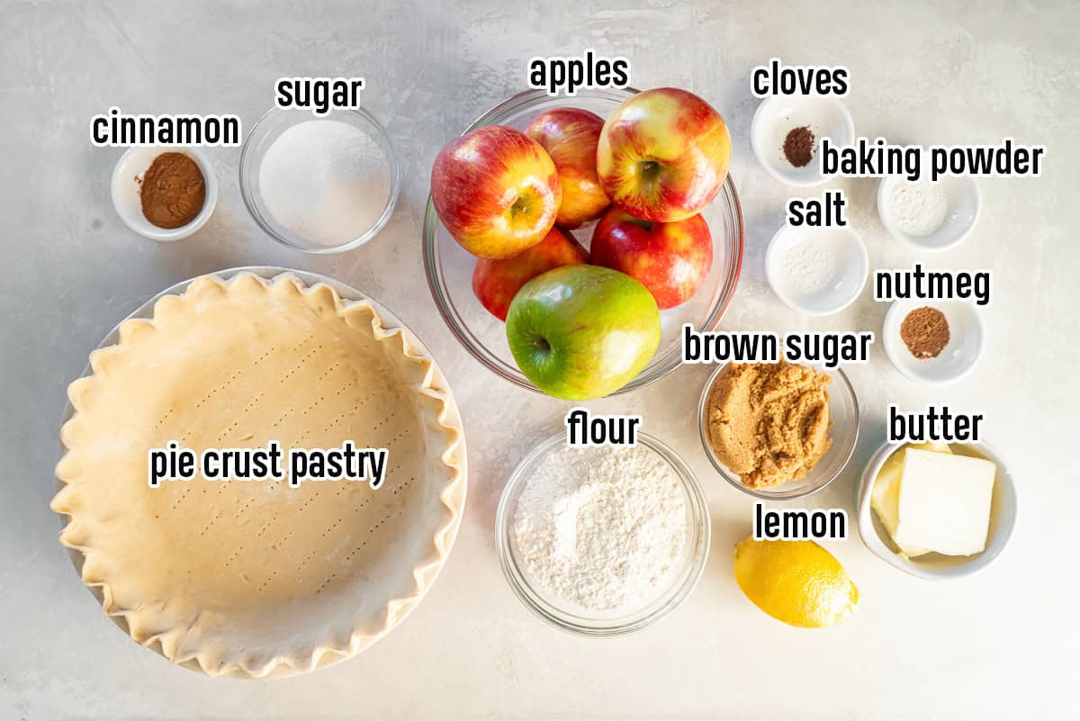 Dutch apple pie ingredients including apples, pie crust pastry, sugar, cinnamon and other ingredients in bowls with text overlay.