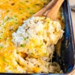 A wooden spoon scooping green chile rice from a casserole dish.