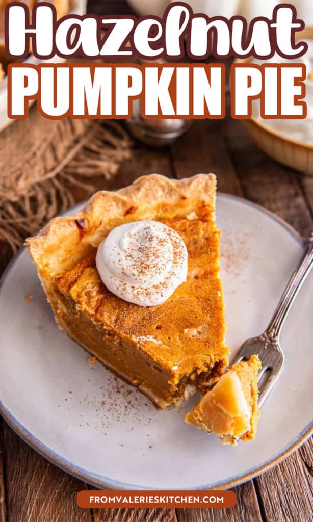 Slice of Hazelnut Pumpkin Pie topped with whipped cream and sprinkled with cinnamon, with a forkful ready to eat on a rustic plate with text overlay.