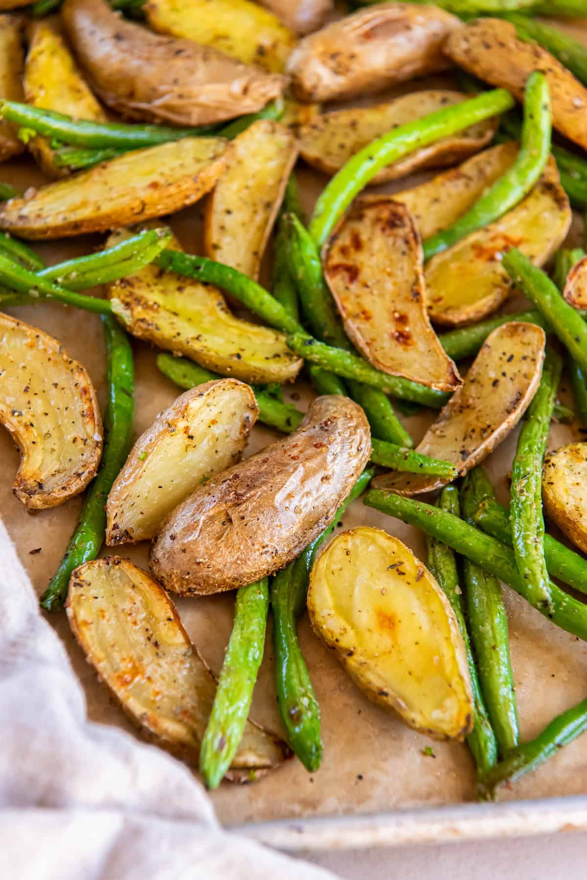 Roasted potatoes and green beans on a sheet pan.