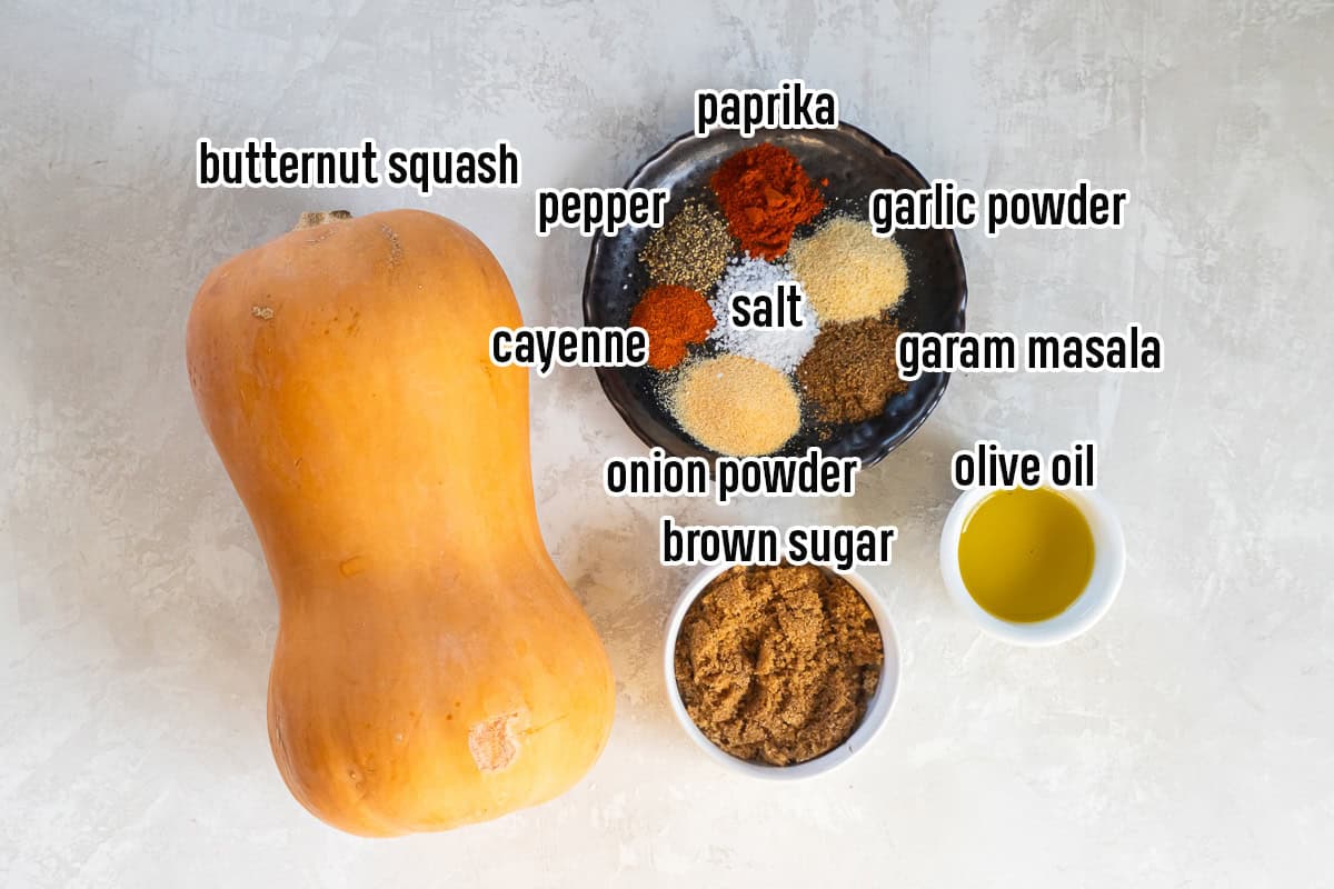 A whole butternut squash, spices on a plate, oil, and brown sugar in small bowls with text overlay.