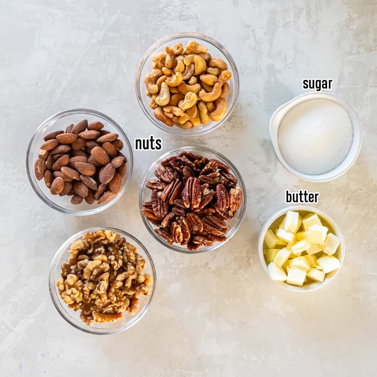 Nuts, sugar, and pats of butter in bowls with text overlay.