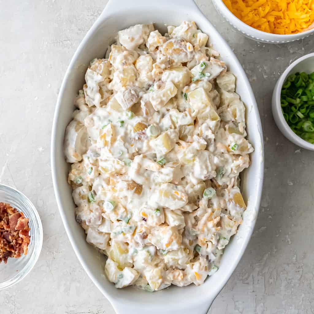 Creamy potato mixture spread in a white baking dish before topping.