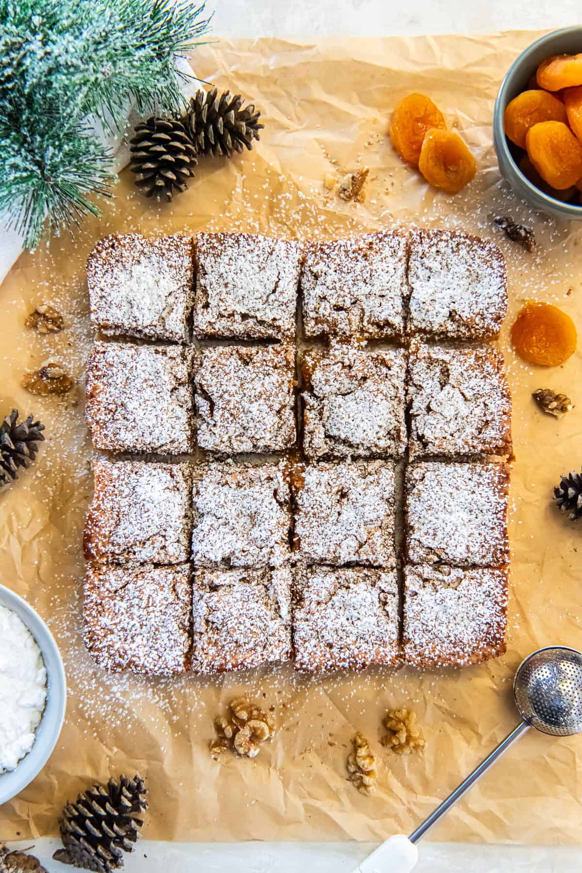 Apricot bars dusted with powdered sugar, cut into squares on parchment paper.