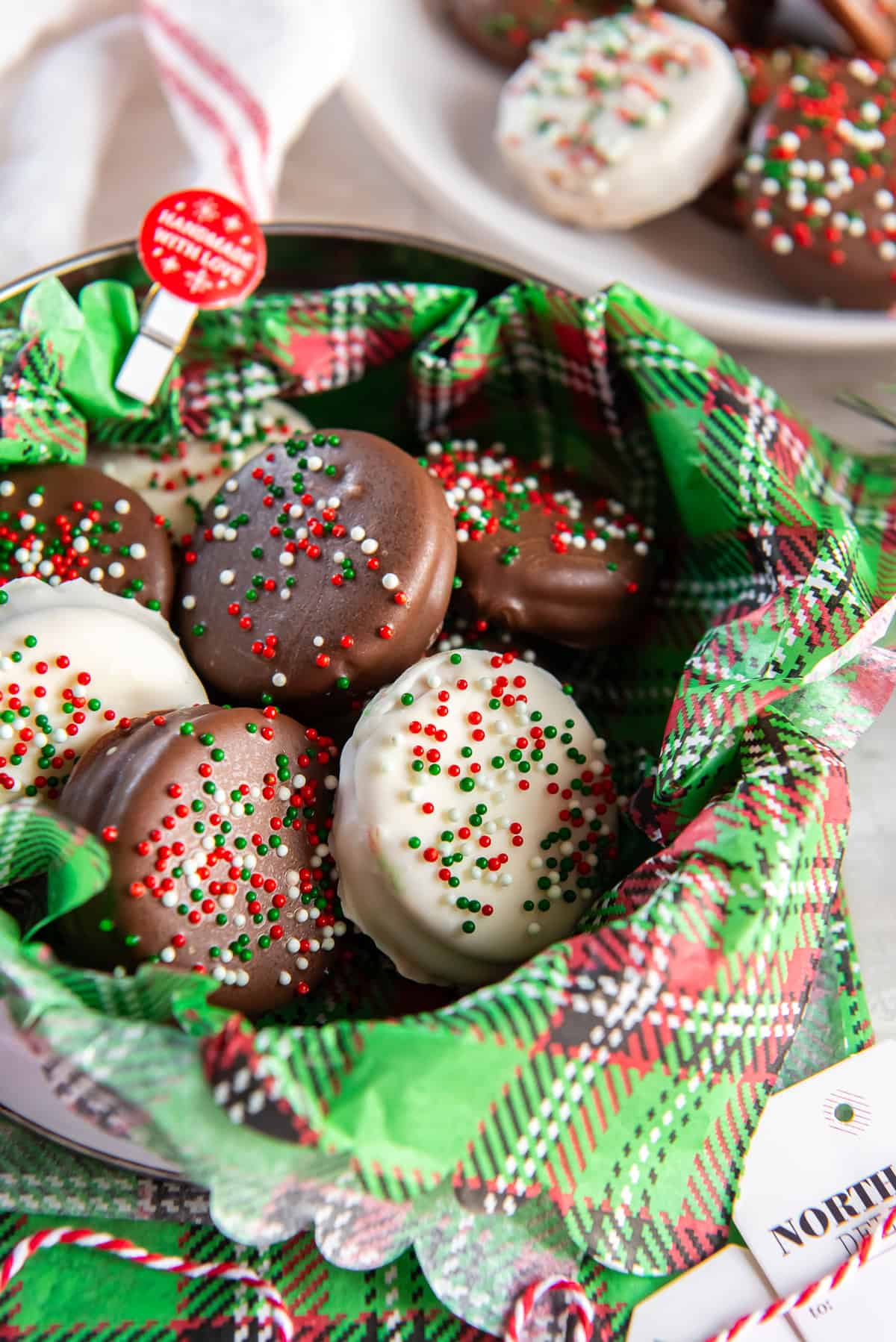 Holiday tin lined with plaid tissue and filled with chocolate- and white-chocolate–dipped peanut butter Ritz cookies topped with red, green, and white sprinkles.