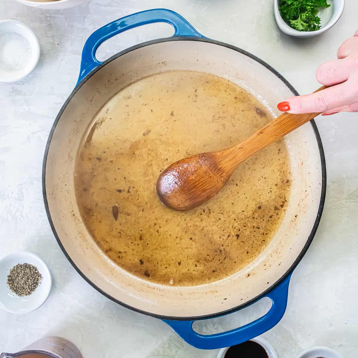 : White wine bubbling in the hot pan as a wooden spoon scrapes up the browned bits.