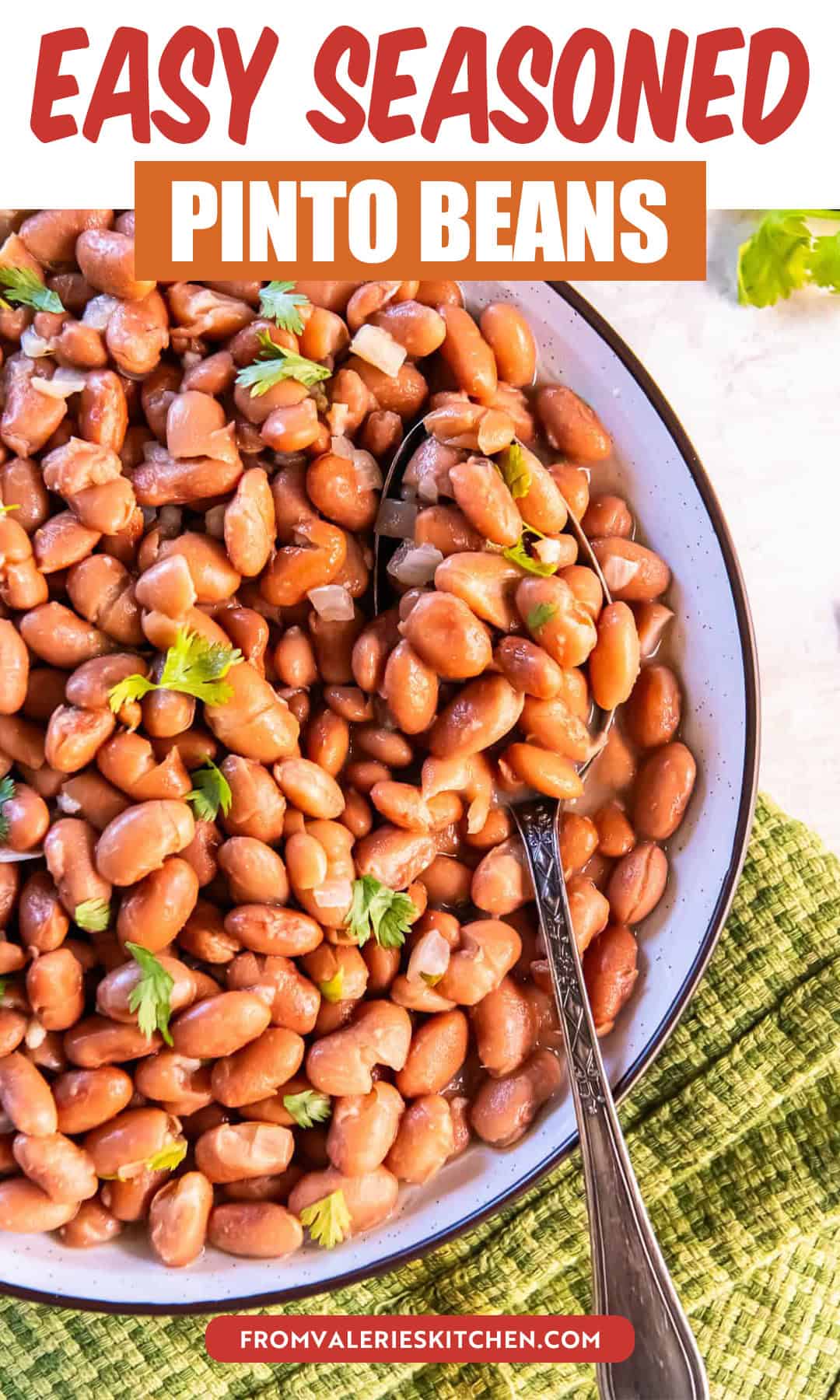 Easy seasoned pinto beans garnished with fresh cilantro in a shallow bowl with a serving spoon with title text overlay.