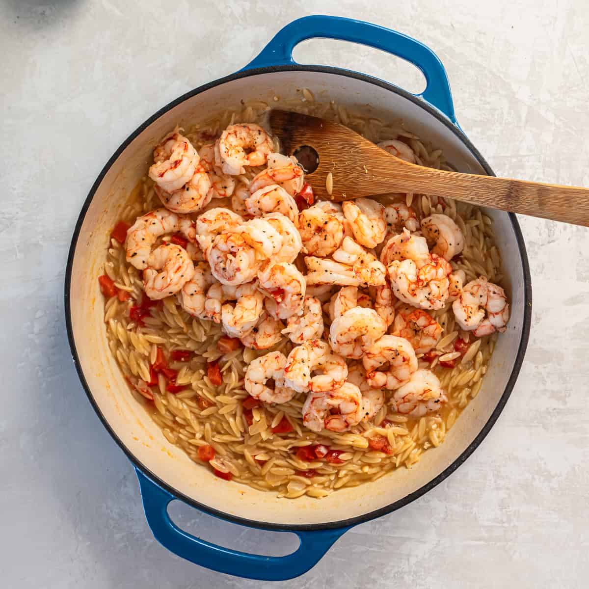 Cooked shrimp added back to the skillet with tender orzo and tomatoes.