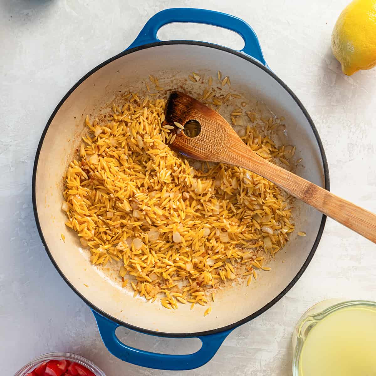 Uncooked orzo stirred into the skillet with onion and garlic to lightly toast.