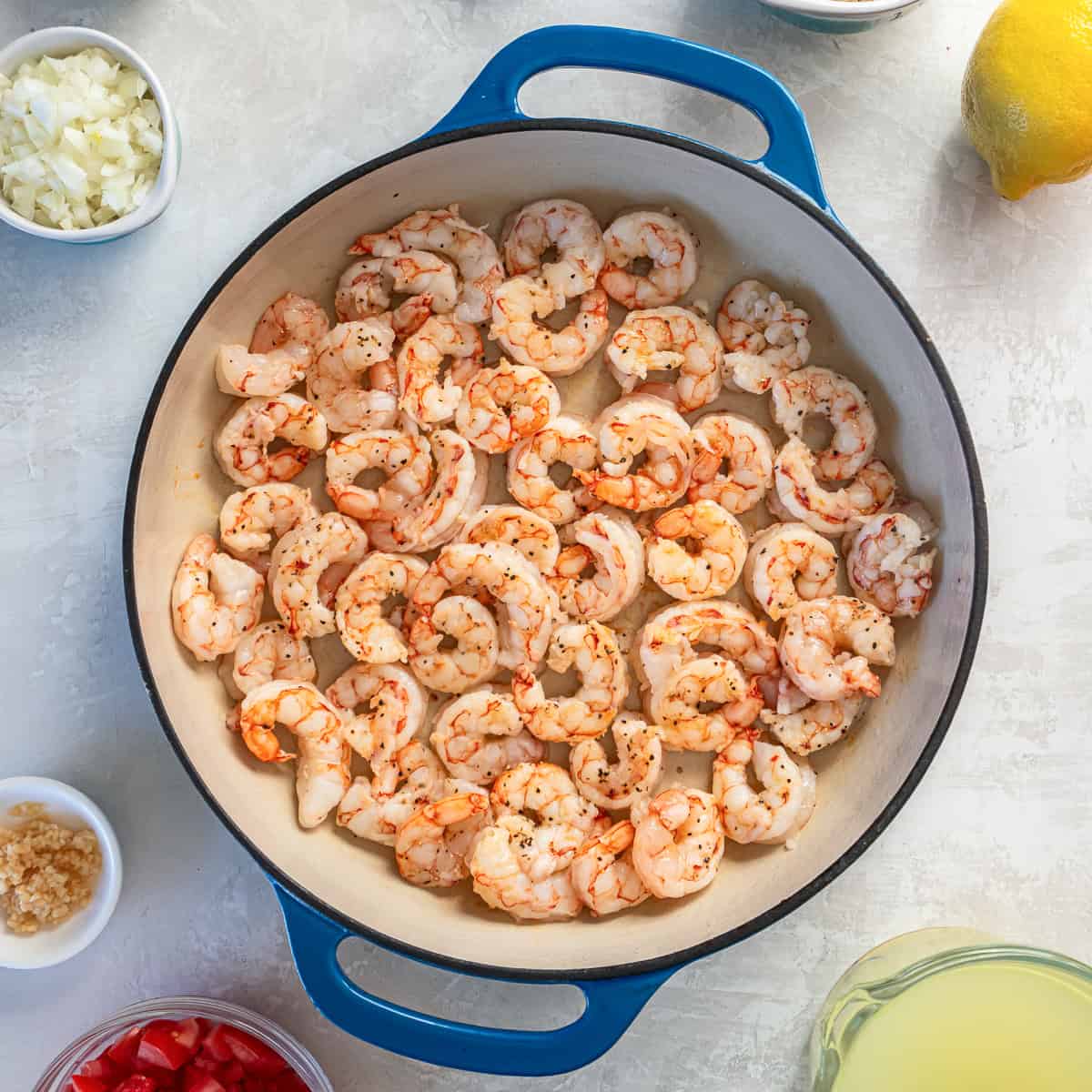 Shrimp cooking in a large skillet until just pink and opaque for orzo pasta with shrimp.