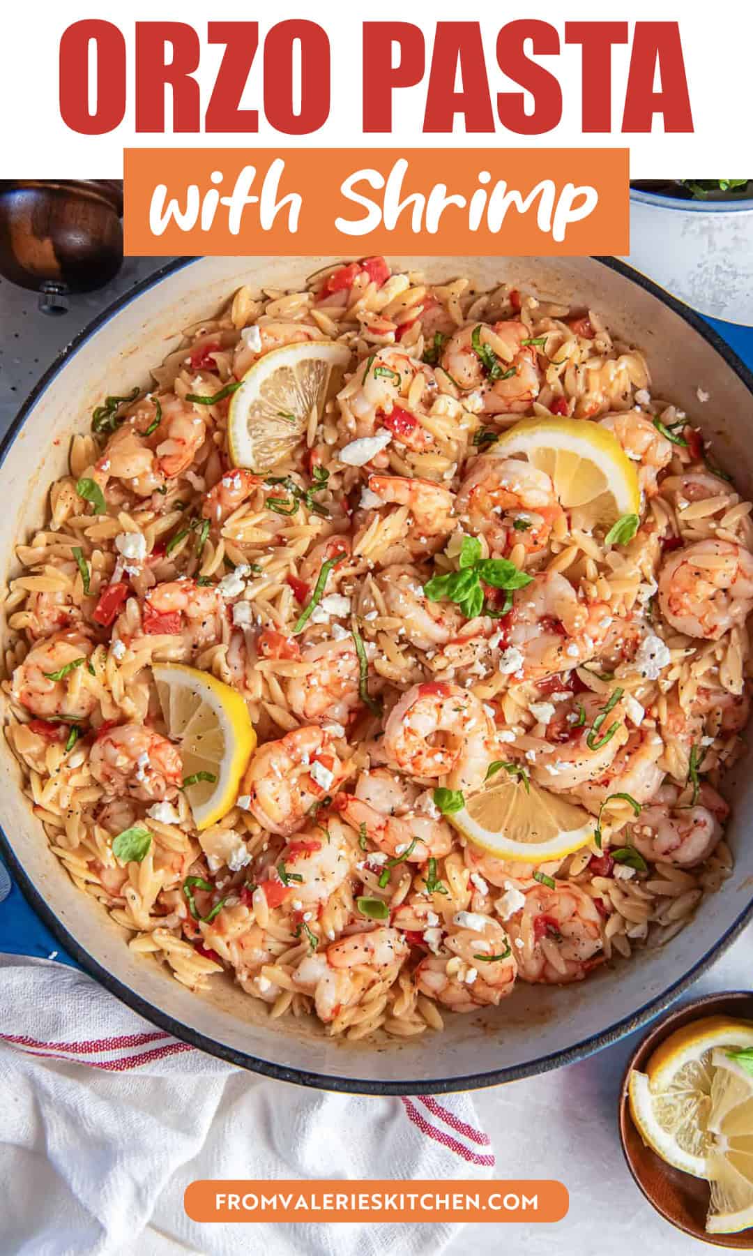 Orzo pasta with shrimp tomatoes feta and basil finished with lemon slices in a pan with title text overlay.