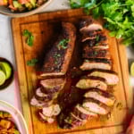 Oven roasted pork tenderloin seasoned with Southwestern spices, sliced and served on a cutting board.