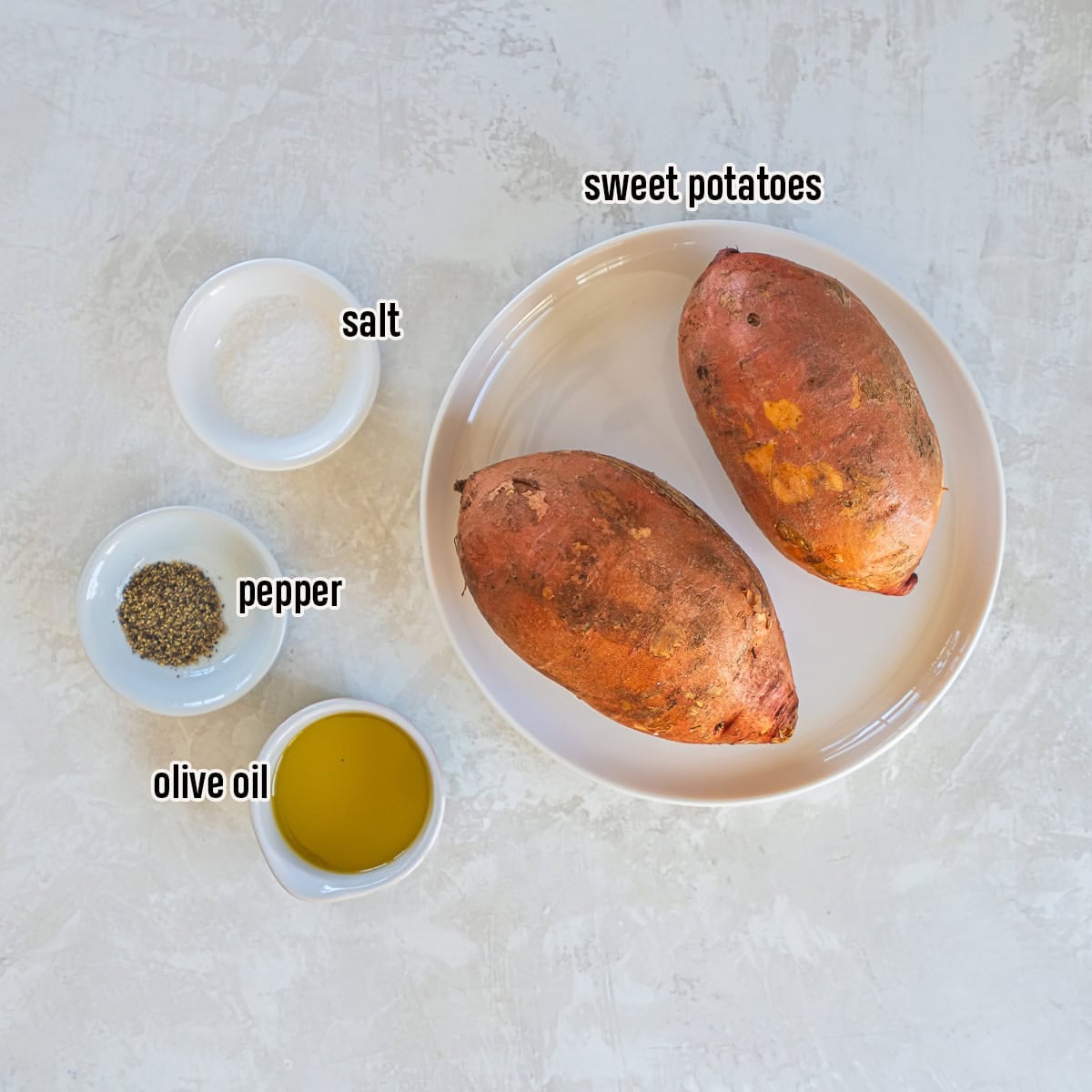 Ingredients for baked sweet potato halves including whole red-skinned sweet potatoes, olive oil, salt, and black pepper