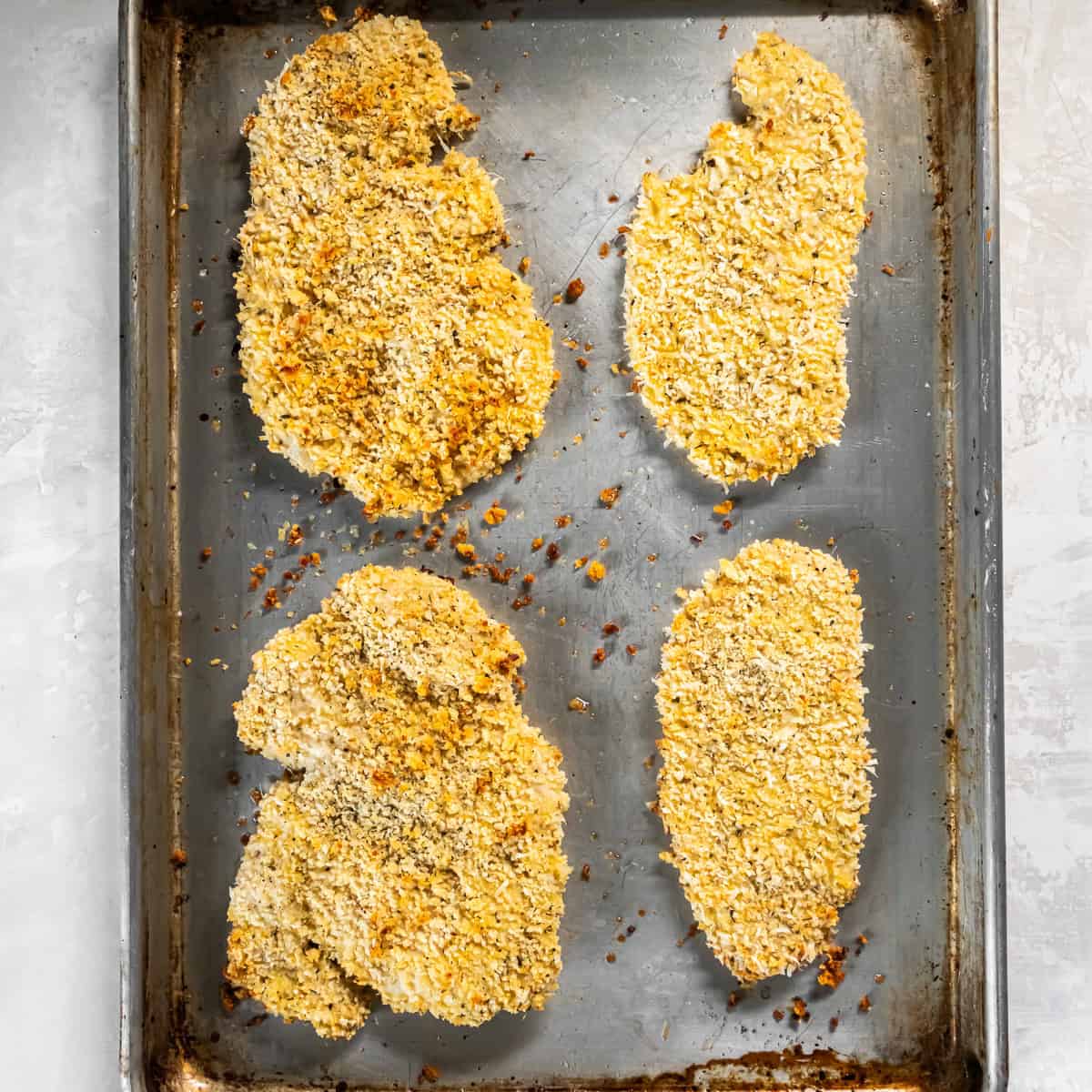 Breaded chicken cutlets baked until lightly golden and crisp on a baking sheet.