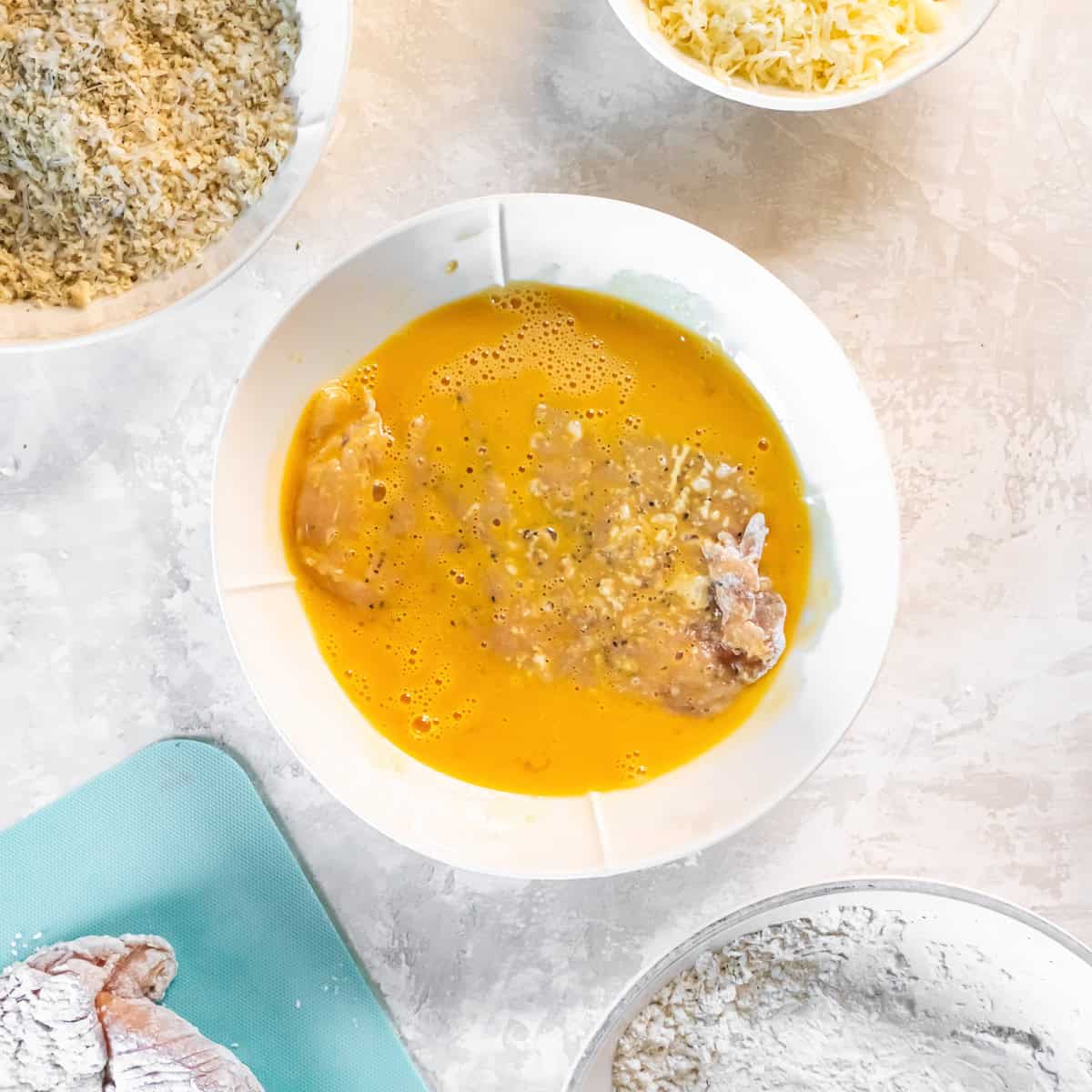 Floured chicken cutlet dipped into an egg and Dijon mixture before coating with breadcrumbs.