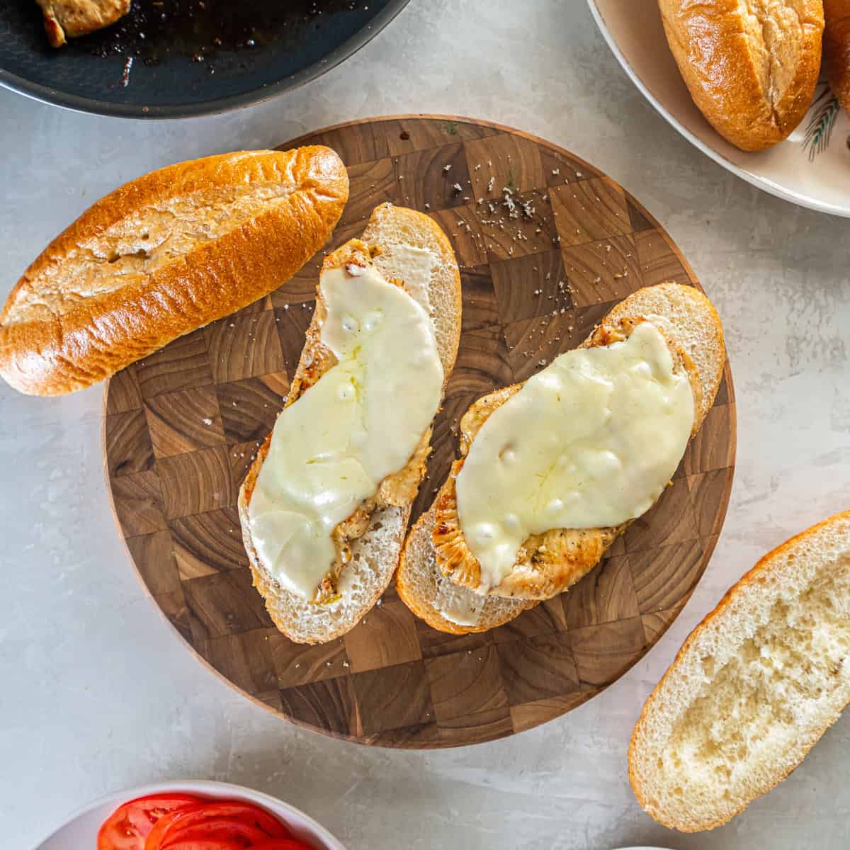 Cooked chicken with melted provolone placed on sub rolls.