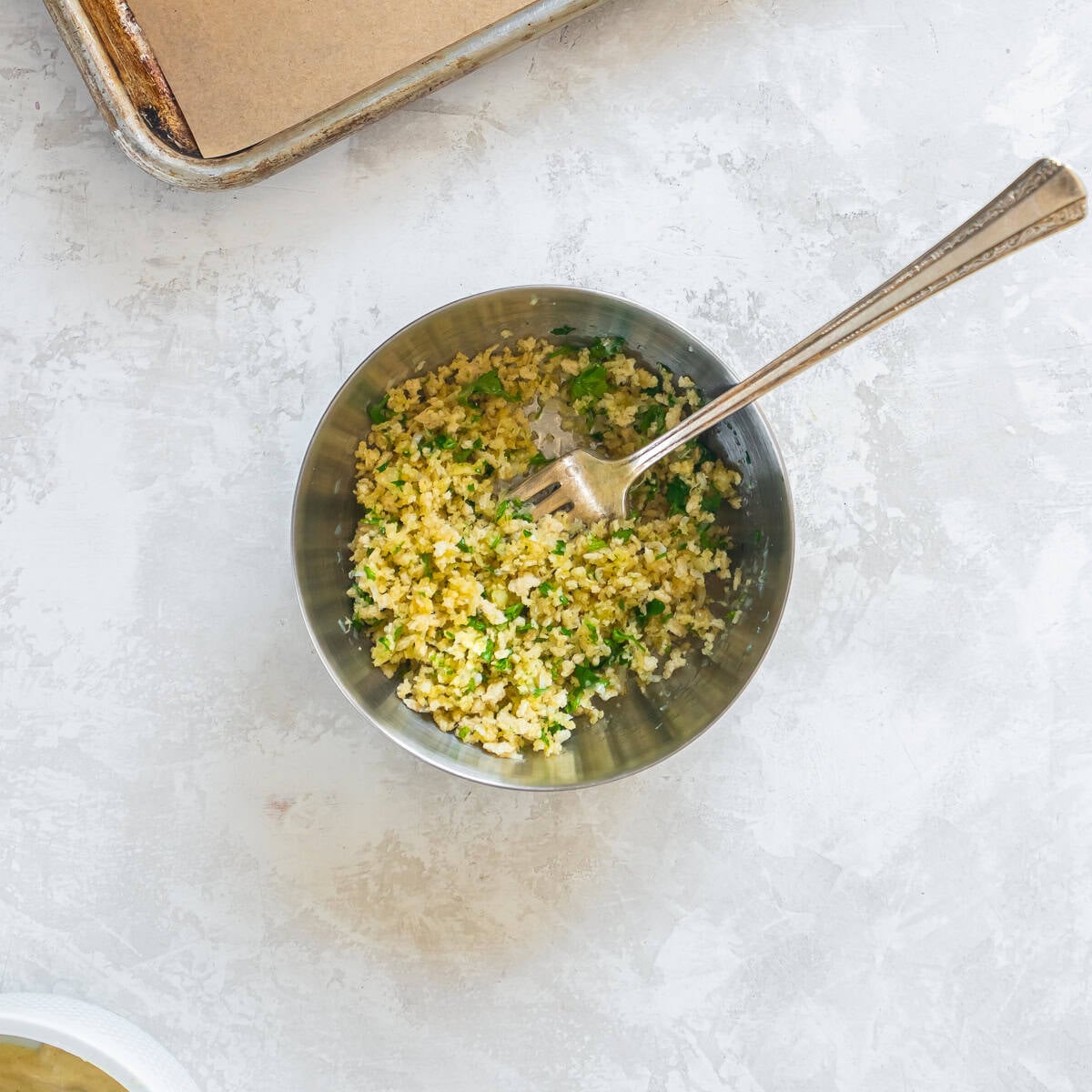 Panko breadcrumbs mixed with Parmesan cheese, parsley, and olive oil in a bowl.