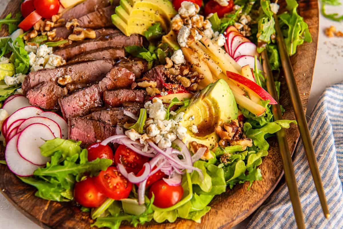 Sliced sirloin, apple, avocado, blue cheese and walnut steak salad with balsamic vinaigrette