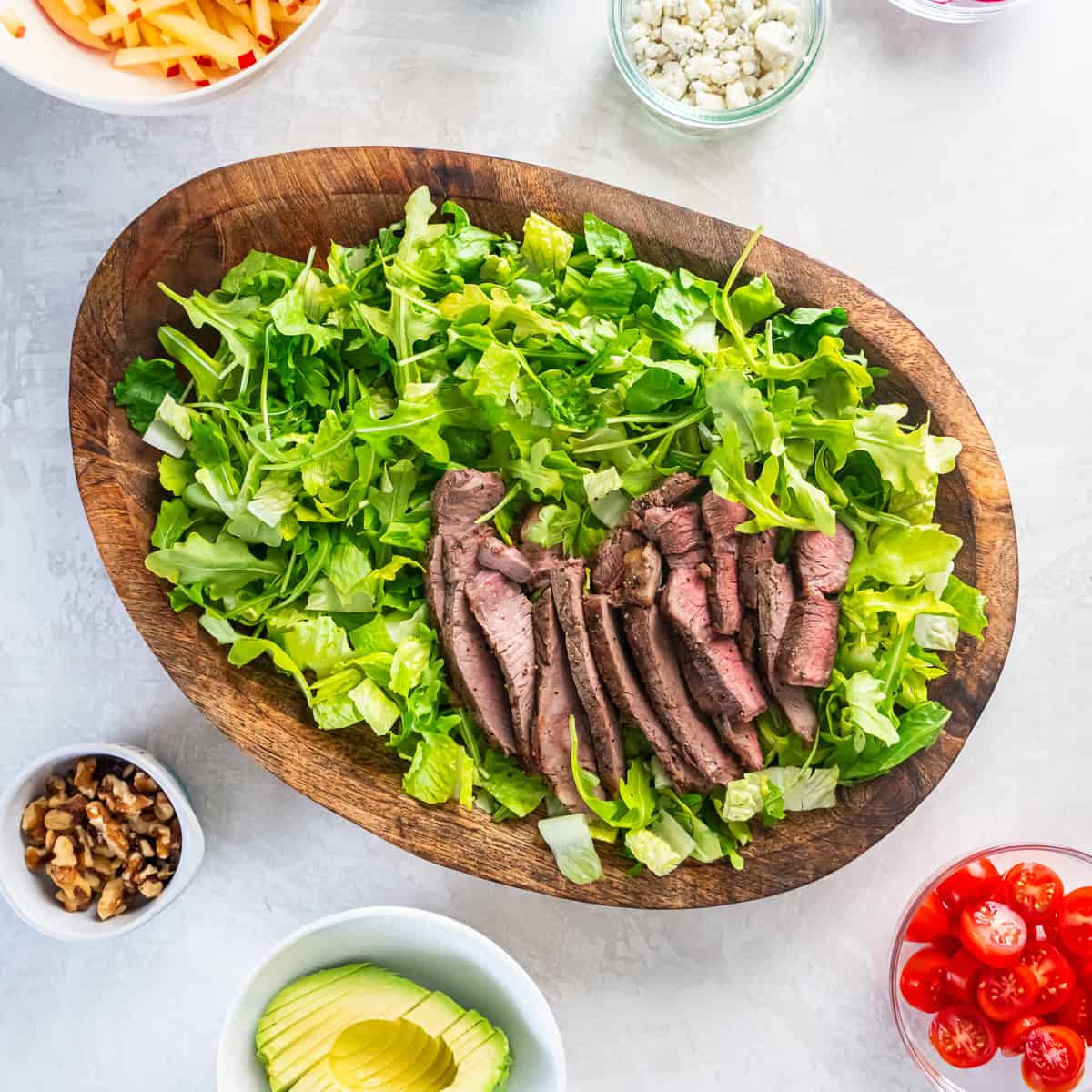 Sliced sirloin steak served over romaine and arugula.
