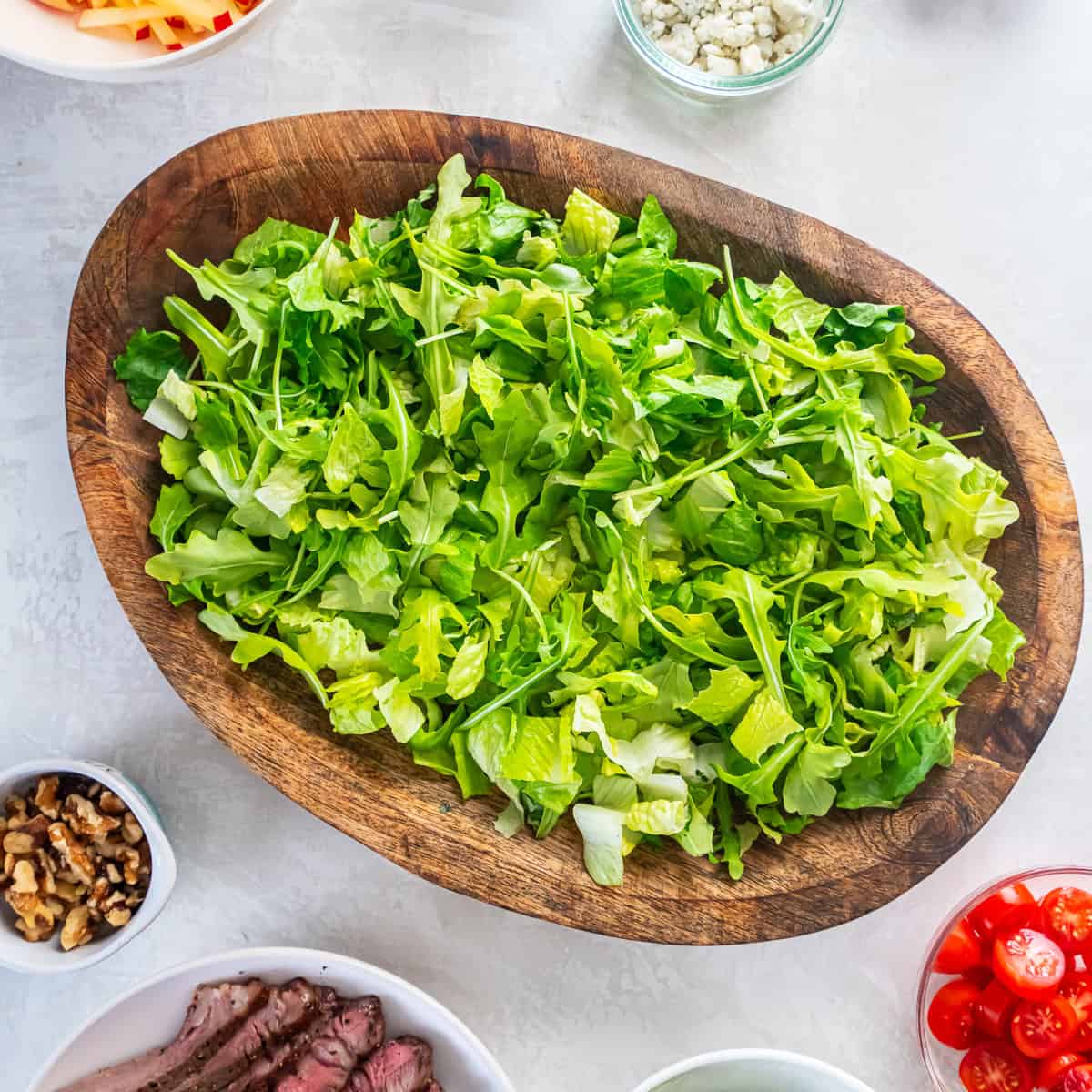 Combine romaine and arugula in a large bowl.
