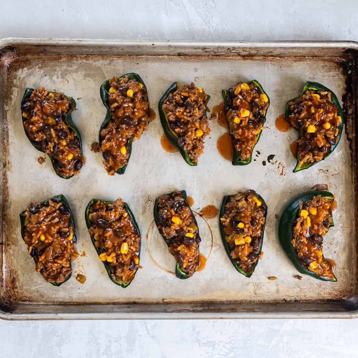 Roasted poblano peppers filled with beef, rice, and bean mixture and topped with enchilada sauce.