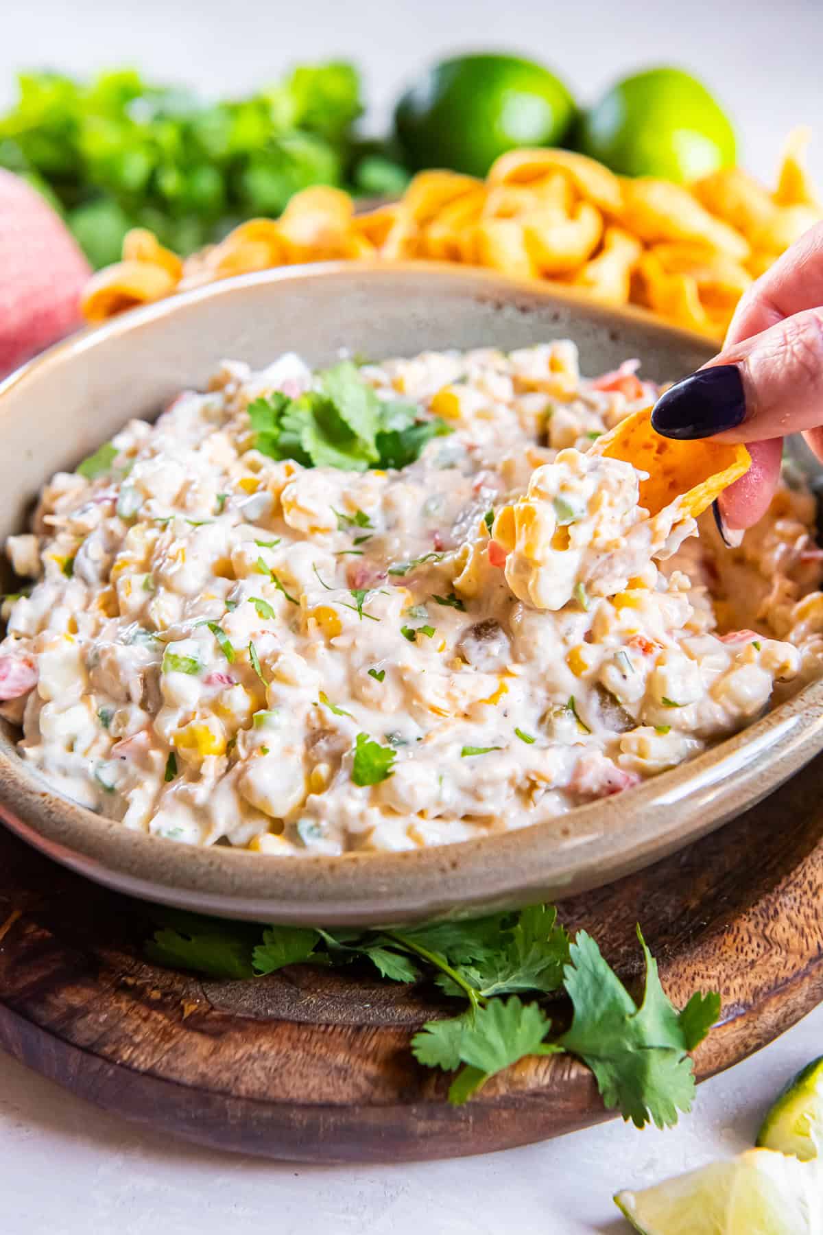 A chip scooping creamy corn dip made with cheddar cheese, green chiles, jalapeño, and frozen corn.