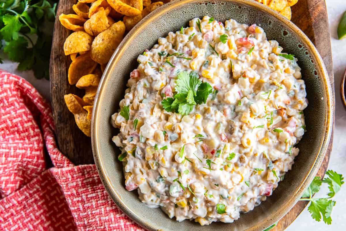 Creamy corn dip made with frozen corn, cheddar cheese, green chiles, and jalapeño served with Fritos Scoops.