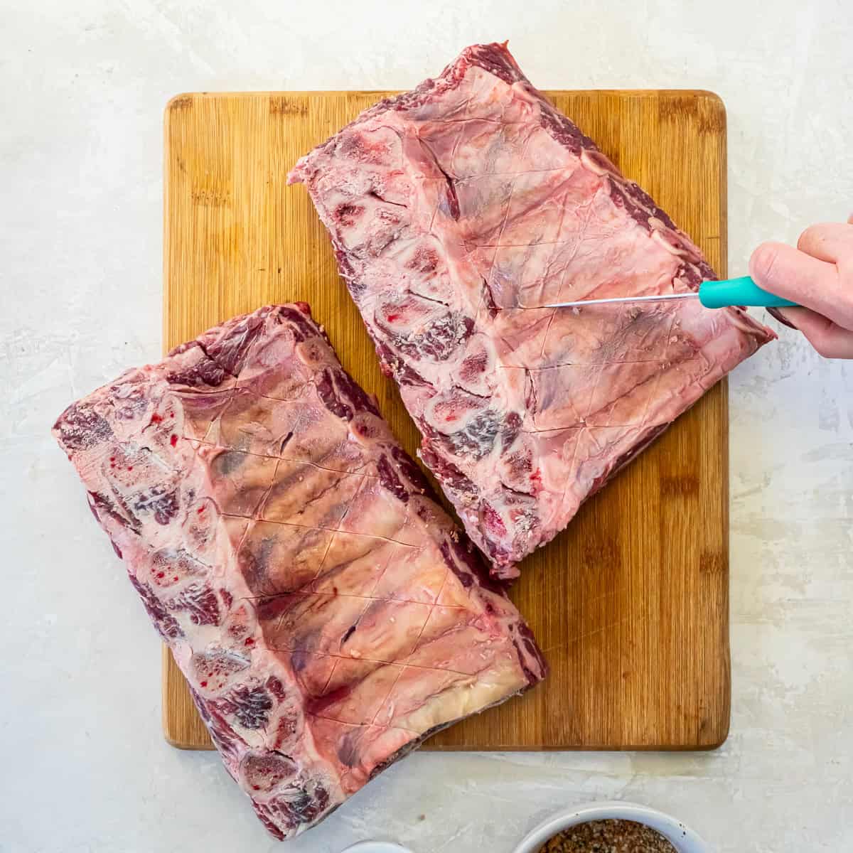 coring the membrane on beef back ribs with a paring knife before seasoning and smoking.